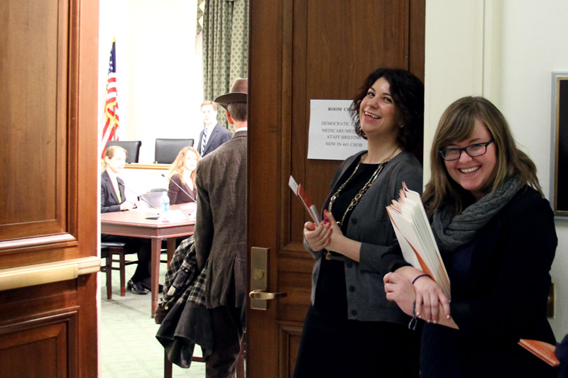 Liz and Katie smile at the entrance to the committee room.