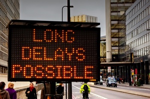 An electronic street sign stating "long delays possible"