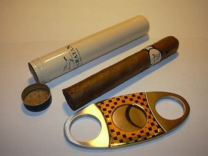 Picture of cigar, flanked by cigar tube and cigar cutter