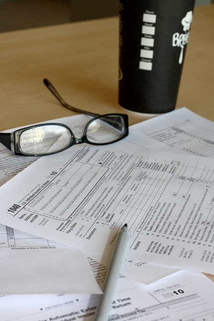 A flickr image of some tax forms, pen and coffee mug.