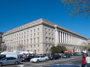 A picture of the grand IRS building from across Constitution Avenue with a blue sky background.