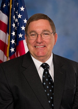 Official portrait of Rep. Michael Burgess, R-Texas, in front of blue background.