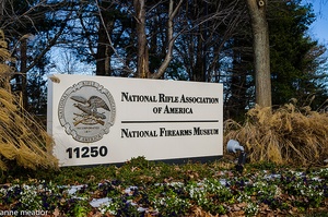 Photo of sign with eagle logo reading National Rifle Association and National Firearms Museum and bearing the street number 11250