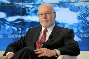 Picture of smiling man in front of blue and white CNBC back drop. He is balding with white beard and glasses, 
