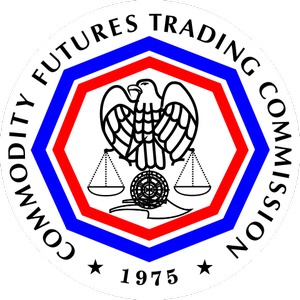  An American bald eagle in black and white holding scales over a black and white wheel enclosed with an inner red octagon and a blue outer octagon and surrounded by the words COMMODITY FUTURES TRADING COMMISSION 1975