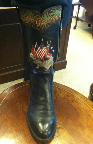 A photo deleted from the official account of Gov. Rick Scott, R-Fla., of a black boot with an elaborate alligator image with flags behind it and '45th Governor' written at the top.