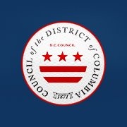 Logo of the Council of the District of Columbia. Blue background, white circle, text "Council of the District of Columbia" circling the DC flag of three red stars above two red stripes.