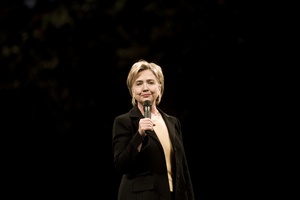 Hillary Clinton stands alone on stage with a microphone