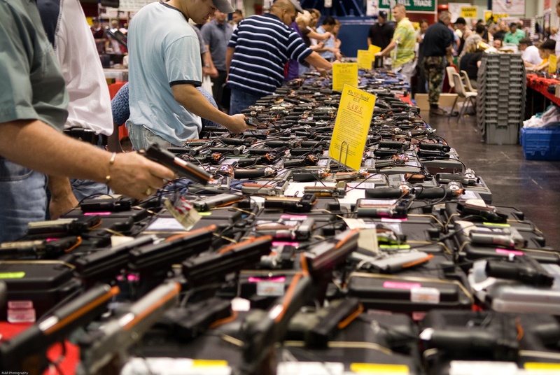 Tables full of guns while interested consumers peruse the options.