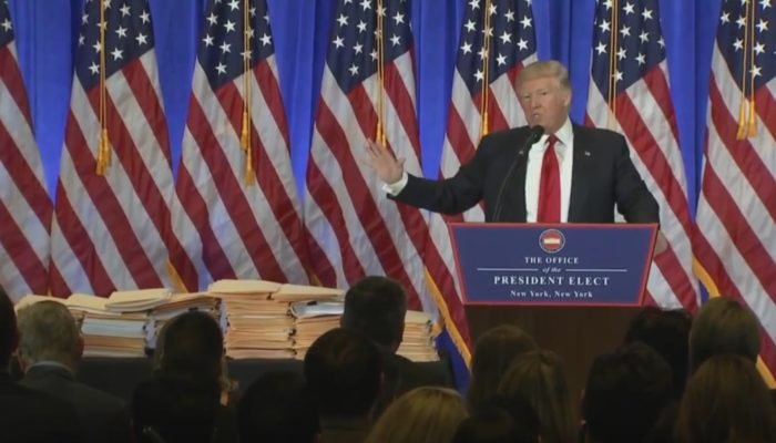 President-elect Donald J. Trump gestures to documents related to his businesses at a January 11, 2017 press conference in New York City.